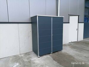 Ein dunkelgrauer Schrank steht im Freien neben einem Gebäude mit Tür.